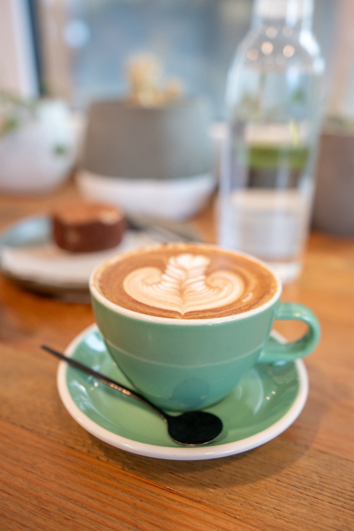 Latte in a green cup on a cafe table